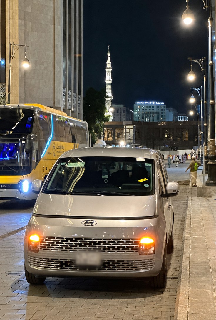 Silver Hyundai Staria MPV waiting near the Prophet's Mosque in Madinah at night