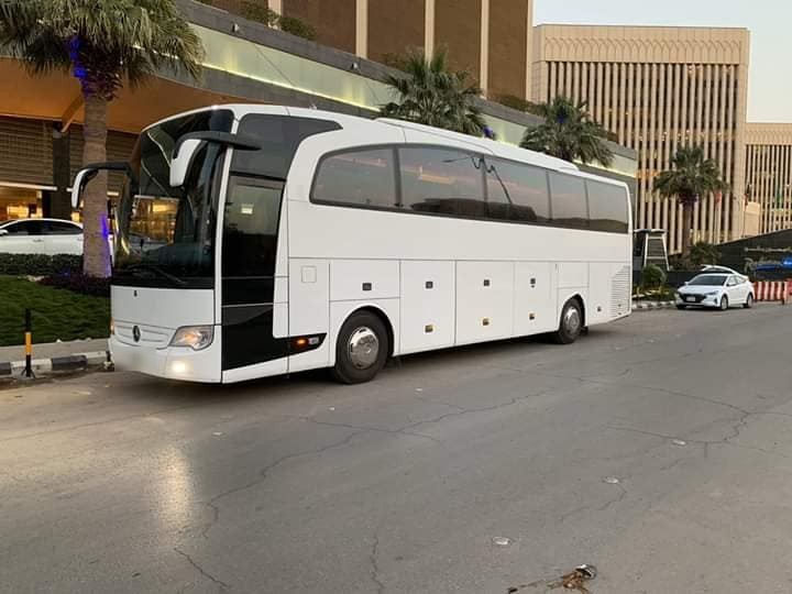 White Mercedes-Benz Travego touring coach outside a hotel in Saudi Arabia